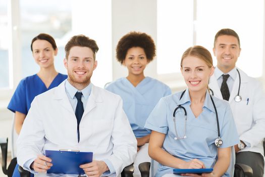 hospital, profession, people and medicine concept - group of happy doctors on seminar in lecture hall at hospital