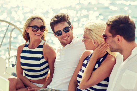 vacation, travel, sea, friendship and people concept - smiling friends sitting and talking on yacht deck