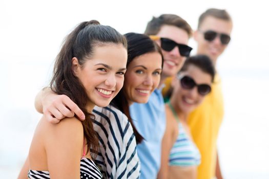 summer holidays, vacation, tourism, travel and people concept - group of happy friends on beach