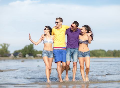 summer holidays, vacation, tourism, travel and people concept - group of happy friends walking and waving hands along beach