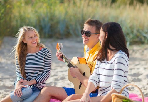 summer holidays, vacation, music, happy people concept - group of happy friends playing guitar on beach