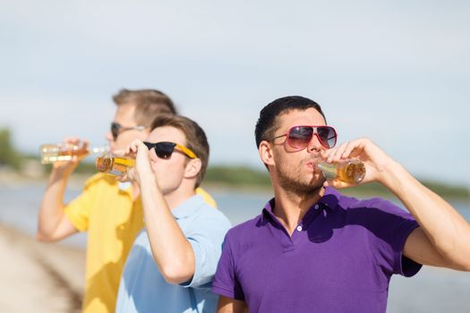 summer holidays, vacation, people and bachelor party concept - group of happy male friends having fun and drinking beer on beach