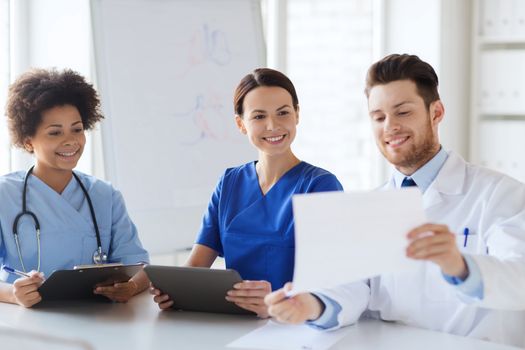 hospital, profession, people and medicine concept - group of happy doctors with tablet pc computers meeting at medical office