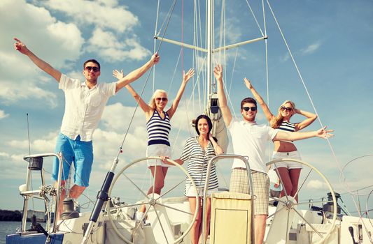 vacation, travel, sea, friendship and people concept - smiling friends sitting on yacht deck and greeting