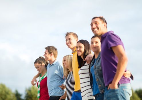 summer holidays, vacation, tourism, travel and people concept - group of happy friends walking along beach