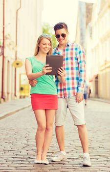 travel, vacation, technology and friendship concept - smiling couple with tablet pc computer in city