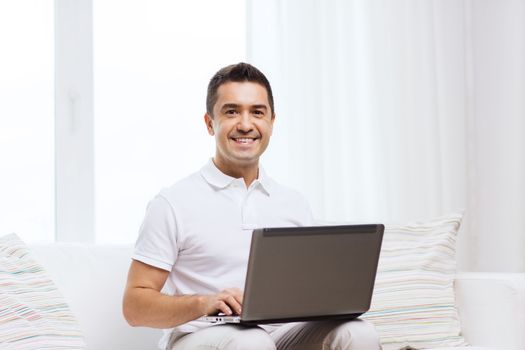 technology, people lifestyle and networking concept - happy man working with laptop computer at home