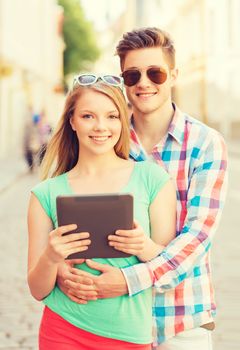 travel, vacation, technology and friendship concept - smiling couple with tablet pc computer in city