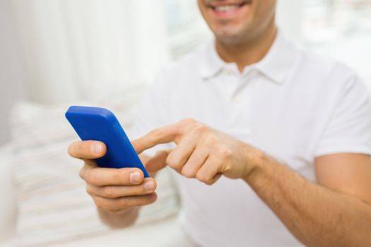 technology, people, lifestyle and communication concept - close up of happy man with smartphone at home