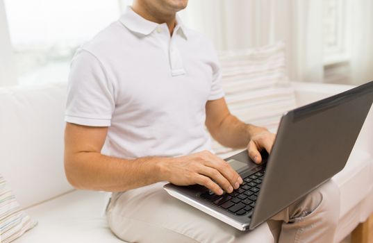 technology, people lifestyle and networking concept - close up of man working with laptop computer at home