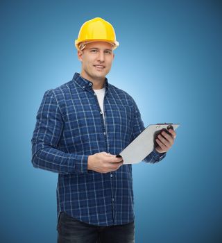 repair, construction, building, people and maintenance concept - smiling male builder or manual worker in helmet with clipboard over blue background