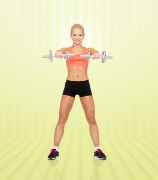 sport, fitness, training, weightlifting and people concept - young sporty woman with dumbbells flexing biceps over yellow striped background