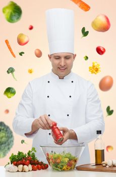 profession, vegetarian, food and people concept - happy male chef cooking and seasoning vegetable salad