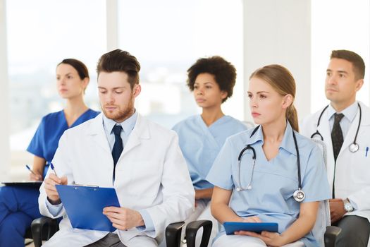 hospital, profession, people and medicine concept - group of happy doctors on seminar in lecture hall at hospital