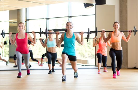 fitness, sport, training and lifestyle concept - group of women with barbells in gym