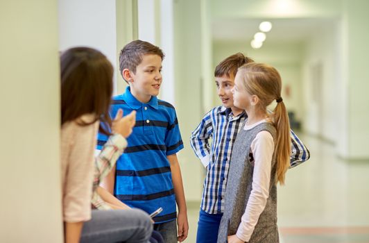 education, elementary school, children, break and people concept - group of smiling school kids talking in corridor