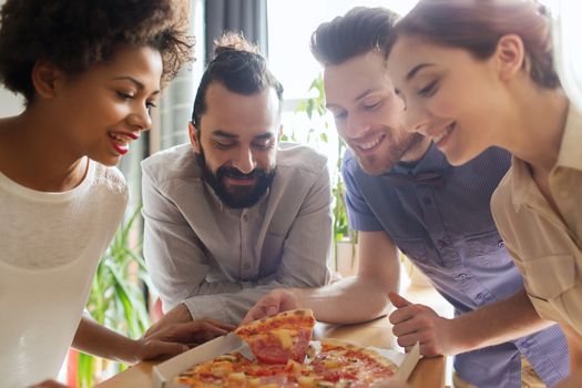 business, food, lunch and people concept - happy business team eating pizza in office