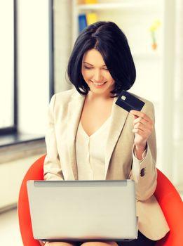 smiling businesswoman with laptop and credit card