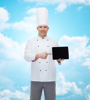 cooking, profession and people concept - happy male chef cook showing tablet pc computer black blank screen over blue sky with clouds background