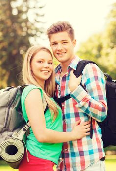 travel, vacation, tourism and friendship concept - smiling couple with backpacks in nature