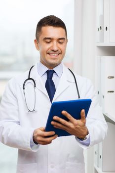 healthcare, technology, profession, people and medicine concept - smiling male doctor in white coat with tablet pc computer in medical office