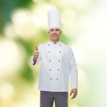 cooking, profession, gesture and people concept - happy male chef cook showing thumbs up over green background
