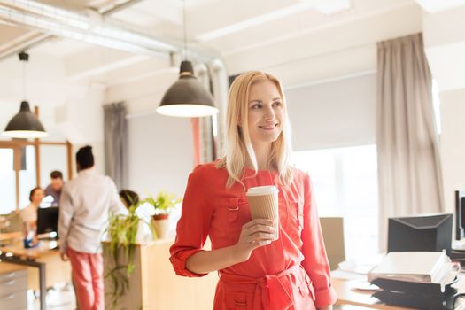 business, startup and people concept - happy businesswoman or creative female office worker with coffee cup