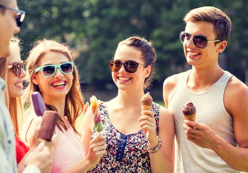 friendship, leisure, sweets, summer and people concept - group of smiling friends with ice cream outdoors