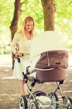 family, child and parenthood concept - happy mother with stroller in park