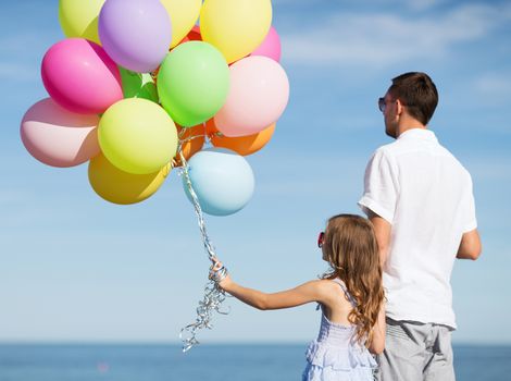 summer holidays, celebration, children and family concept - father and daughter with colorful balloons