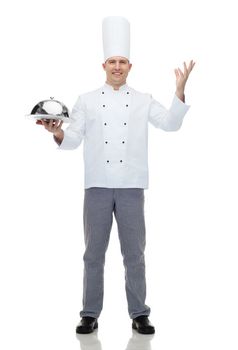 cooking, profession and people concept - happy male chef cook holding cloche