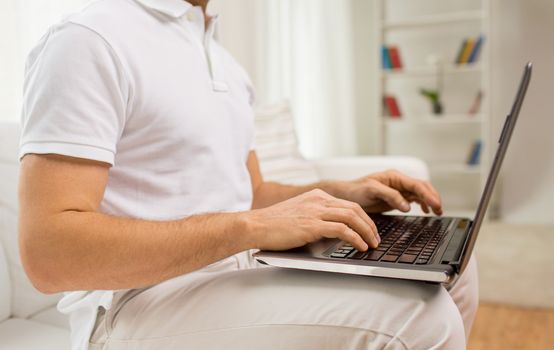 technology, people lifestyle and networking concept - close up of man working with laptop computer at home