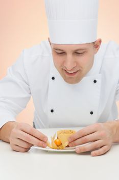 cooking, profession, haute cuisine, food and people concept - happy male chef cook decorating dessert over beige background