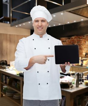 cooking, profession and people concept - happy male chef cook showing tablet pc computer black blank screen over kitchen background