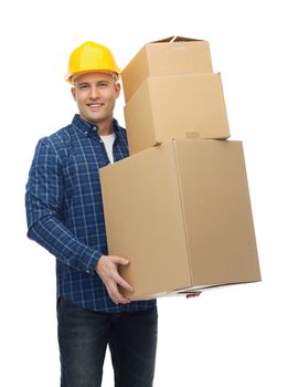 repair, building, construction, loading and delivery concept - smiling man or loader in helmet with cardboard boxes