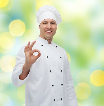 cooking, profession, gesture and people concept - happy male chef cook showing ok sign over green lights background