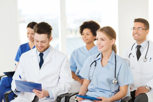 hospital, profession, people and medicine concept - group of happy doctors on seminar in lecture hall at hospital