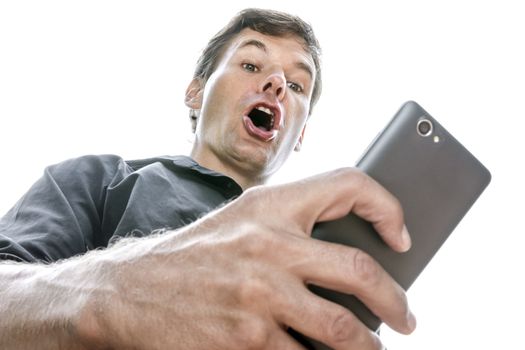 Low angle closeup Caucasian man looking down at his cell phone shows expression of shock as he opens his mouth in disbelief on white background