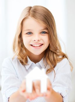 home and family concept - little girl holding white paper house