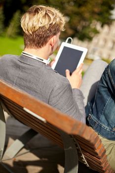 leisure, summer, technology and people concept - young man tablet pc computer in park or campus