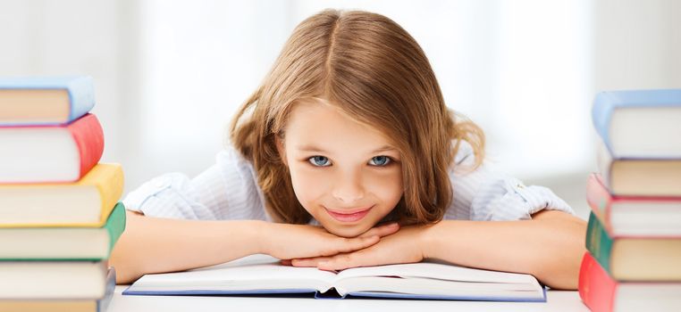 education and school concept - smiling little student girl with many books at school