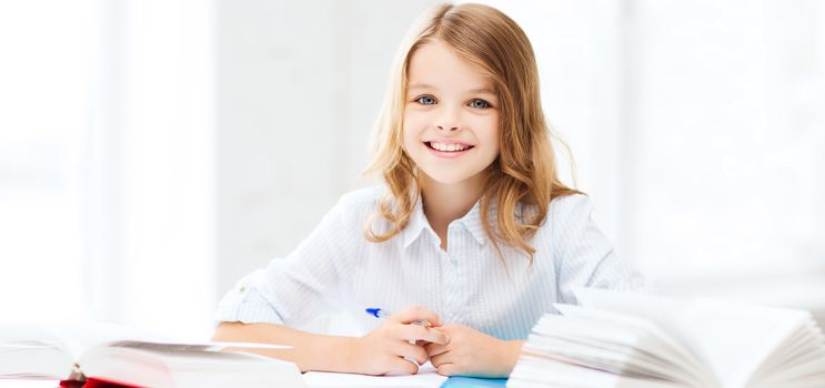 education and school concept - little student girl studying at school