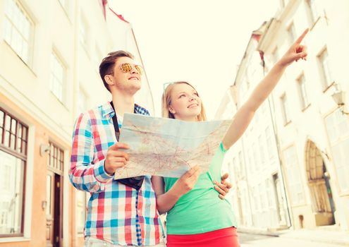 travel, vacation, technology and friendship concept - smiling couple with map and photo camera exploring city