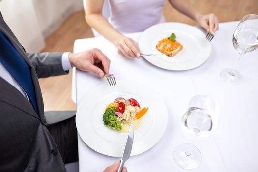 restaurant, food, people, date and holiday concept - close up of couple eating appetizers at restaurant