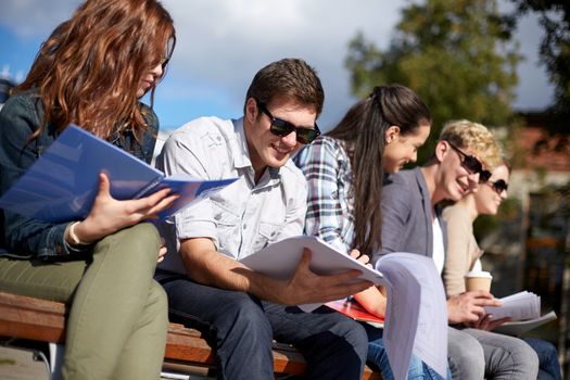 summer, friendship, education and teenage concept - group of happy students with notebooks learning at campus