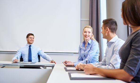 business, people and teamwork concept - group of smiling businesspeople meeting in office