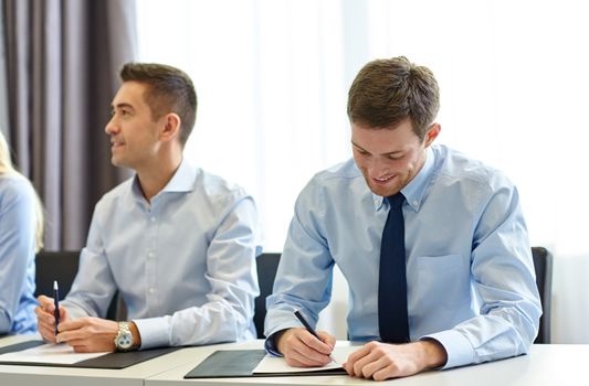 business, people and teamwork concept - group of smiling businesspeople meeting on presentation in office