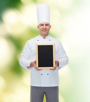 cooking, profession, advertisement and people concept - happy male chef cook showing and holding blank menu board over green background