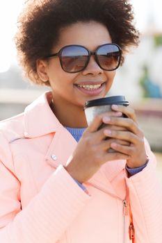 drinks and people concept - smiling african american young woman or teenage girl drinking coffee from paper cup outdoors