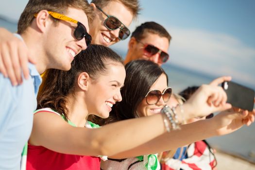 summer holidays, vacation, happy people concept - group of friends taking selfie with cell phone on the beach